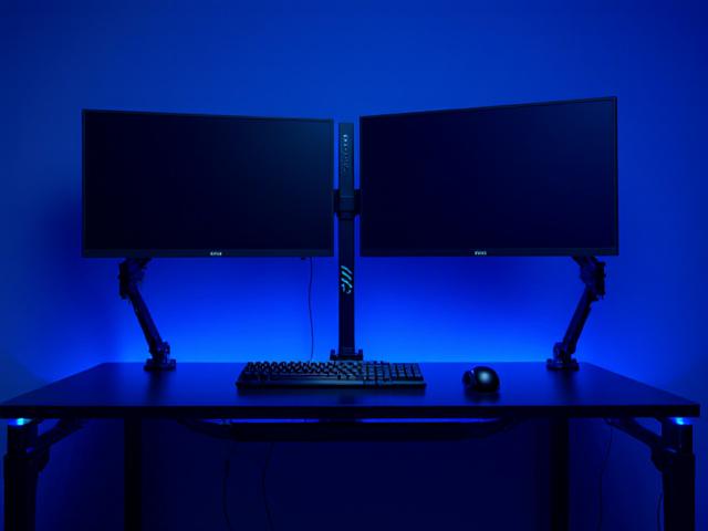 A desk cluttered with monitor stands transformed by articulating wall arms